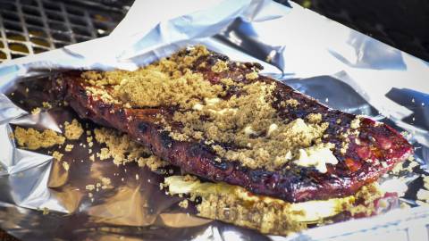 Rack of ribs rests on top of a sheet of aluminum foil on a grill during the Grill & Chill BBQ Festival in Big Bear Lake, CA